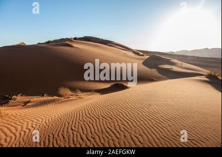 Die aufgehende Sonne wirft lange Schatten über die Dünenlandschaft des Khomas Region in Central Western Namibia. Stockfoto