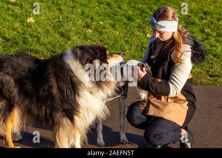 Northampton, UK, Wetter, 9. Dezember 2019, einem hellen, sonnigen Morgen in Abington Park mit einem kühlen Wind, ein junges Mädchen, das einen Aufwand von ein paar Tagen auf Ihrem morgendlichen Spaziergang, wickelte gegen die Kälte. Credit: Keith J Smith./Alamy leben Nachrichten Stockfoto