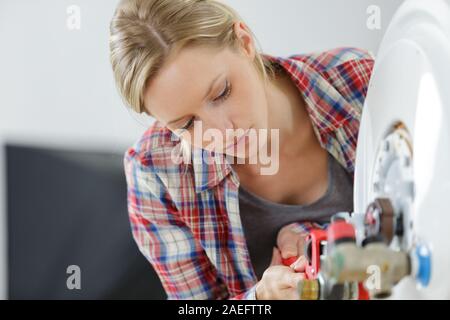 Portrait von weiblichen Klempner Arbeiten am Kessel Stockfoto