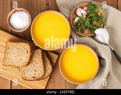 Zwei braune Schüssel Kürbiscremesuppe auf dem Braunen dunklen Hintergrund, Ansicht von oben. Lecker, lecker, gesund, Nahrung, Hintergrund, Tisch, frisch, Stockfoto