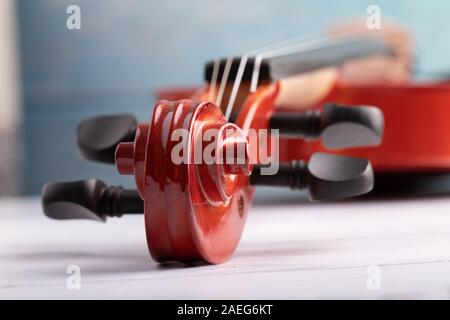 Nahaufnahme Violine headstock Orchester instrumental über weiß Holz- Hintergrund wählen Sie Fokus flache Tiefenschärfe Stockfoto