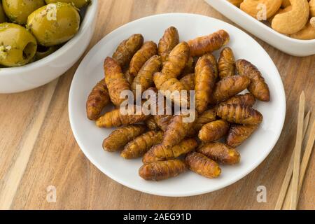 Schüssel mit gesalzener knusprige Seidenraupen für einen Snack Stockfoto