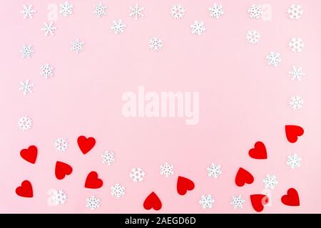 Valentinstag Hintergrund. rote Herzen und Schneeflocken auf rosa Hintergrund. Valentines Tag Konzept. Flach, Ansicht von oben, kopieren Raum Stockfoto