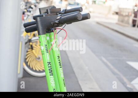 Wien, ÖSTERREICH - NOVEMBER 6, 2019: Kiwi Ride Logo auf einer Reihe ihrer Elektroroller in Wien. Kiwiride ist ein Transport Unternehmen spezialisiert. Stockfoto