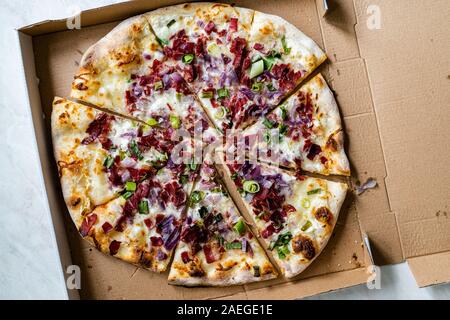 Flammkuchen, Pizza Scheiben/Traditionelle Tarte Flambee mit Creme Fraiche, Sahne, Käse, Speck und roten Zwiebeln in Feld. Traditionelle Fast Food. Stockfoto