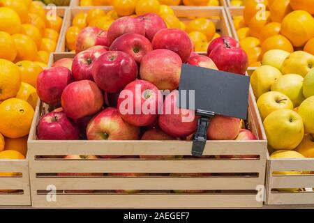 Rote Äpfel in einer Holzbox mit einem Preis Stockfoto