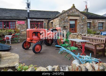 Die alten roten Traktor angezeigt außerhalb des beliebten dent Village Museum und Heritage Center auf der Main Street, Dent, Yorkshire Dales National Par Stockfoto