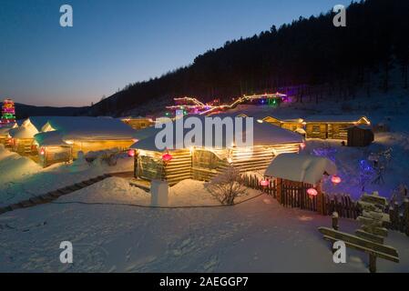 Nacht Blick auf den beleuchteten Häuser im Schnee Dorf am Stadtrand von Arxan City, North China Autonome Region Innere Mongolei am 9. Dezember, 2. Stockfoto