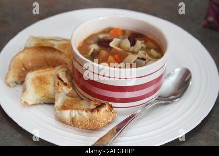Suppe mit Toast auf der Seite auf einer Platte Stockfoto
