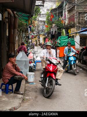 Männer auf Motorrädern in der engen Straße Lane, Hanoi, Vietnam, Südostasien Stockfoto