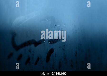 Wolke Regen Marke Bild in Abbildung mit einem Finger auf die klassische blaue Farbe abends oder morgens Fenster feucht beschlagenen Glas mit Tropfen gezeichnet. Abstrakt Hintergrund Stockfoto