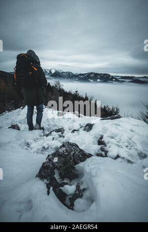 Männliche Wanderer auf einem Berg und die Aussicht genießen im Winter Stockfoto
