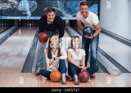 Schönes Portrait. Junge fröhliche Freunde viel Spaß beim Bowling Club an den Wochenenden Stockfoto