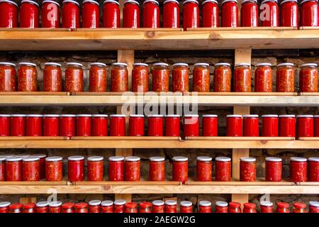 Tomaten und Paprika Paste in Töpfen. Tomatenmark Gläser aufgereiht auf Regalen. Tomaten und Paprika Sauce Stockfoto