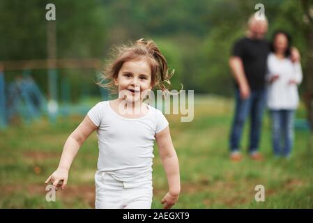 Vorderansicht. Großmutter und Großvater haben Spaß im Freien mit Enkelin. Malerei Konzeption Stockfoto
