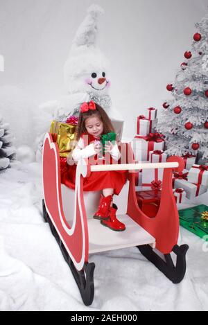 Mädchen sass auf Santa's sleigh Stockfoto