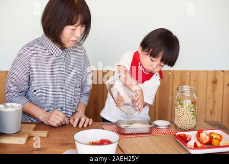 Japanische Frau und Junge in einem Hofladen, der Zubereitung von Mahlzeiten. Stockfoto