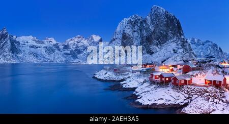 Kabinen die Traditionelle norwegische Fischer, Rorbuer auf der Insel Hamnøy, Reine auf den Lofoten im Norden Norwegens. In der Dämmerung im Winter fotografiert. Stockfoto