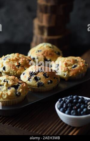 Hausgemachte bröckeln nach oben Blueberry Muffins mit Beeren auf schwarzem Hintergrund. Low Key noch Leben mit natürlichem Licht Seitenansicht Stockfoto