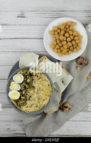 Hummus ist ein traditionelles Gericht der östlichen Küche in eine graue Platte, auf einem weißen Holz- Hintergrund. Hausgemachte von kichererbse, Sesampaste, Zitrone, dekoriert Stockfoto