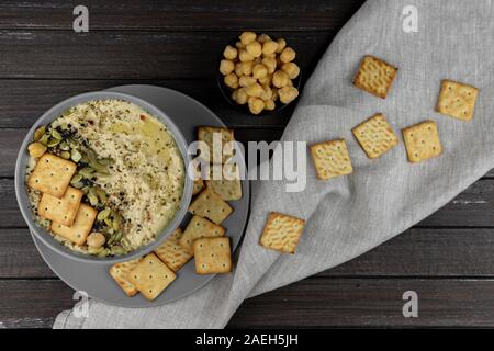 Hummus ist ein traditionelles Gericht der östlichen Küche in eine graue Platte, auf einem dunklen Hintergrund. Hausgemachte von kichererbse, Sesampaste, Zitrone, dekoriert wit Stockfoto