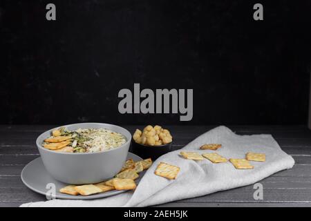 Hummus ist ein traditionelles Gericht der östlichen Küche in eine graue Platte, auf einem dunklen Hintergrund. Hausgemachte von kichererbse, Sesampaste, Zitrone, dekoriert wit Stockfoto