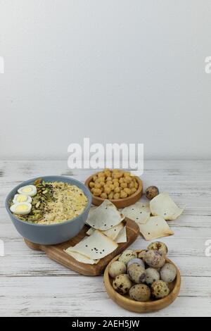 Hummus ist ein traditionelles Gericht der östlichen Küche in eine graue Platte, auf einem weißen Hintergrund aus Holz und Karton. Hausgemachte von kichererbse, Sesampaste, Zitrone Stockfoto