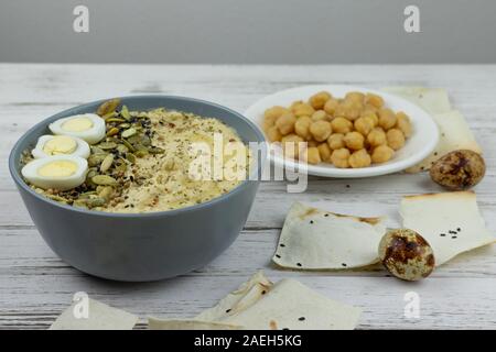 Hummus ist ein traditionelles Gericht der östlichen Küche in eine graue Platte, auf einem weißen Holz- Hintergrund. Hausgemachte von kichererbse, Sesampaste, Zitrone, eingerichtet wi Stockfoto