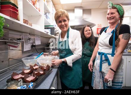 SNP-Chef Nicola Sturgeon mit Angela Crawley (Mitte), SNP Kandidat für Lanark und Hamilton Osten und Eigentümer Kym Fletcher (rechts), hilft Muffins bei einem Besuch der Wallace Kaffee Zimmer in Lanark auf der allgemeinen Wahlkampagne Trail zu machen. Stockfoto