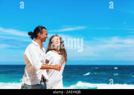 Happy Family auf Hochzeitsreise holiday - Just married junges Paar, das Spaß, durch Wasser Meer Strand surfen entlang laufen. Aktiv Sommer lifestyle Stockfoto