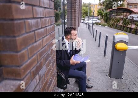 Ernsthafte bärtiger Mann sein leckeres Sandwich genießen. Stockfoto