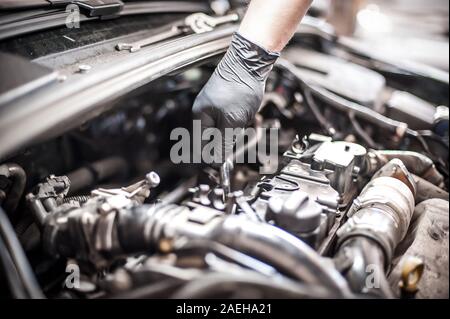 Entfernen und Ändern von Ventilen. Automechaniker Kontrolle Automobil Ventile unter die Haube des Fahrzeugs Service Shop Stockfoto