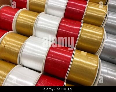 Glänzende, metallische Weihnachten ribbon Zeichenfolgen in Rot, Gold, Weiß & Silber. Ansicht von oben. Schöne Textur der sparkly Urlaub Dekorationen. Stockfoto