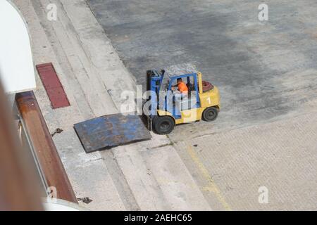 Aruba -11/4/19: Hafen Hafenarbeiter mit einem Gabelstapler setup eine Rampe Passagiere aus dem Schiff zu transportieren. Stockfoto