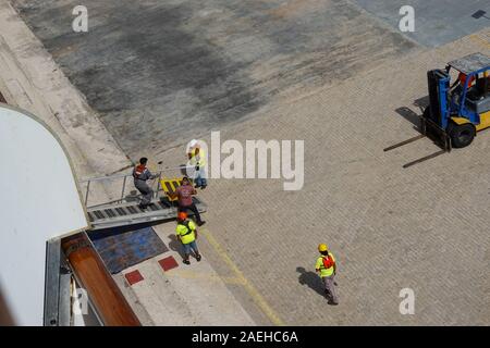 Aruba -11/4/19: Hafen Hafenarbeiter und cruise ship Crew arbeiten hart daran, die Einrichtung einer Rampe Passagiere aus dem Schiff zu transportieren. Stockfoto