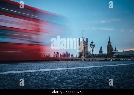 London. Klassische rote Doppeldeckerbus über die Westminster Bridge vor dem Parlamentsgebäude und Big Ben in London. Stockfoto