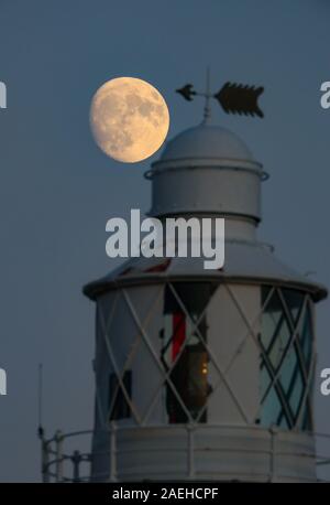 Keyhaven, Hampshire, UK. 9. Dezember 2019, UK Wetter: Das Waxing Gibbous Mond erhebt sich auf einem klaren Abend oben Hurst Point Lighthouse im Keyhaven, Hampshire vor der Full Cold Moon, die an diesem Donnerstag, 12. Dezember, 5.12 Uhr GMT. Kredit Stuart Martin/Alamy leben Nachrichten Stockfoto