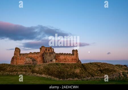 East Lothian, Schottland, Vereinigtes Königreich, 9. Dezember 2019. UK Wetter: ein klarer Himmel mit einer fast vollständigen Waxing gibbous Mond über dem zerstörten Vorhangfassade des 14.jahrhunderts Tantallon Castle mit Blick auf den Firth von weiter Stockfoto