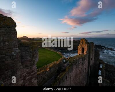 East Lothian, Schottland, Vereinigtes Königreich, 9. Dezember 2019. UK Wetter: Sonnig klaren Himmel wirft die letzten Strahlen der untergehenden Sonne auf den Ruinen der Vorhangfassade des 14.jahrhunderts Tantallon Castle mit Blick auf den Firth von weiter mit Berwick Gesetz über den Horizont Stockfoto