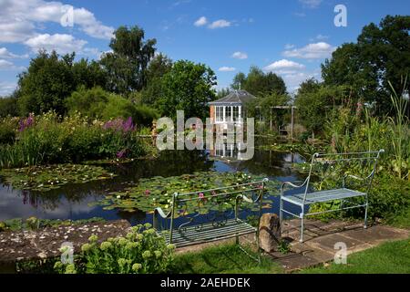 Garten Gartenhaus mit Blick über die ornamentale Teich mit Seerosen im Englischen Garten, England Stockfoto