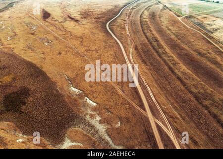 Luftaufnahme von staubigen Schotterstraße in der normalen Landschaft von Drone pov Stockfoto