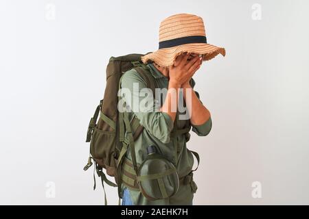 Wanderer Frau mit Rucksack, Hut und Wasser Kantine über isoliert weißer Hintergrund mit traurigen Ausdruck für Gesicht mit den Händen und weinte. Depressio Stockfoto