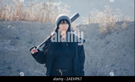 Brutale Frau von hooligan Banden geht mit einem Baseballschläger in der Einöde Stockfoto