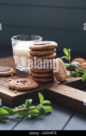 Gesund vegan Glutenfrei Zuckerfrei cookie Frühstück. Erdnussbutter, Haferflocken und almond Cookies mit Schokolade Tropfen serviert mit der Milch und Minze Stockfoto