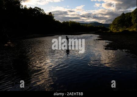 Ein Fischer Waten in einen Stream bei Sonnenuntergang Stockfoto