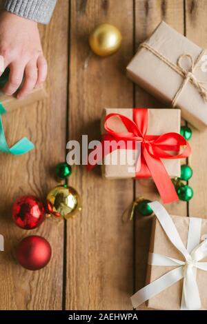 Frau verpacken Weihnachten Geschenke auf Holz- Hintergrund Stockfoto
