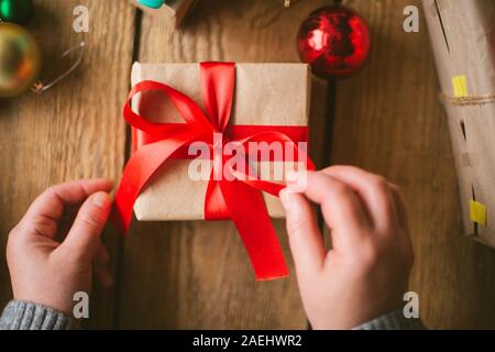 Frau verpacken Weihnachten Geschenke auf Holz- Hintergrund Stockfoto