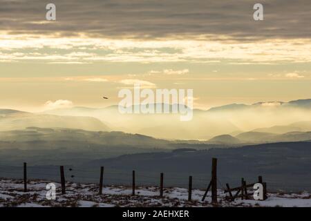 Blick auf die Seenplatte Hügel von Hartside in den North Pennines bei Sonnenuntergang, mit einem RAF Trainer Flugzeug überfliegen. Stockfoto