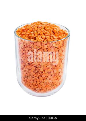 Trocken rote Linsen in einem Glas auf einem weißen Hintergrund. Zutaten für vegetarische Suppe pürieren. Gesunde Ernährung und veganes Essen. Vorderansicht. Stockfoto