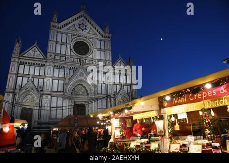 Florenz, Dezember 2019: der berühmte Weihnachtsmarkt auf der Piazza Santa Croce mit der Basilika im Hintergrund. Florenz, Italien. Stockfoto